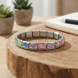 Primer plano de pulsera de acero inoxidable con diseños de animales y pronombres