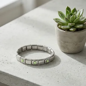 Vue rapprochée du bracelet modulaire italien en acier avec des breloques étoiles vertes