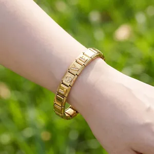 Dettaglio di un bracciale componibile in acciaio dorato con ciondoli LOVE scintillanti