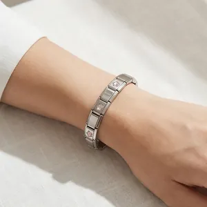 Gros plan d'un bracelet modulaire italien en acier inoxydable avec des étoiles roses