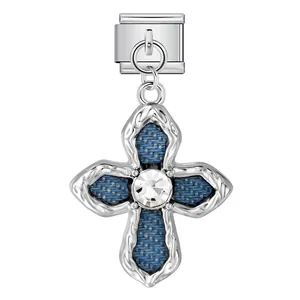 Detailansicht eines italienischen Charm-Kreuzes mit blauem Denim und Kristallzentrum.