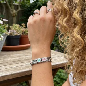 Close-up of leopard print star Italian modular bracelet on a woman's wrist outdoors