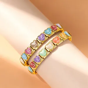 Nahaufnahme von herzförmigen Tierkreis-Charm-Armbändern aus vergoldetem Edelstahl