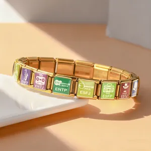Detailed macro shot of gold stainless steel MBTI bracelet charms with music icons.