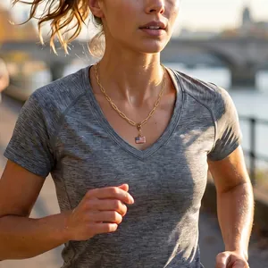 Detailansicht einer goldenen Büroklammer-Halskette mit US-Flaggen-Anhänger beim Joggen