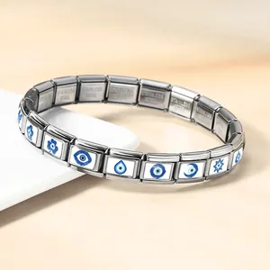 Dettaglio dei ciondoli Evil Eye blu sulle maglie del bracciale modulare in acciaio.