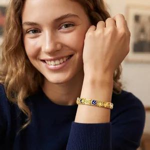 Close-up detail of the space-themed gold modular charm bracelet on a model's wrist