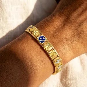 Macro view of a gold space-themed Italian modular charm bracelet worn on a wrist