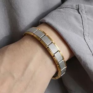 Gros plan d'un bracelet modulaire italien en acier inoxydable à texture quadrillée