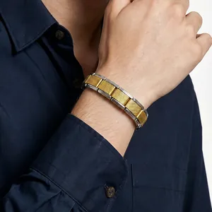 Détail du bracelet modulaire en acier inoxydable bicolore avec texture maillée au poignet