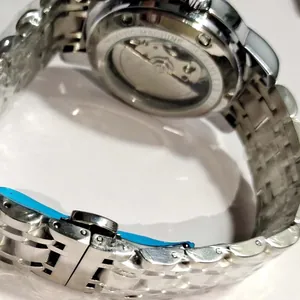 Close-up view of automatic mechanical watch movement and stainless steel strap detail