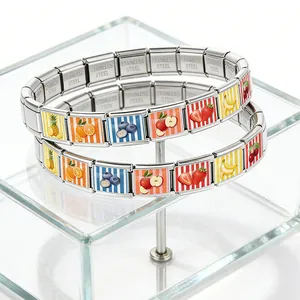 Macro detail of stainless steel Italian charm bracelet with colorful fruit patterns
