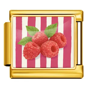 Close-up of gold Italian modular charm with raspberry pattern on striped background