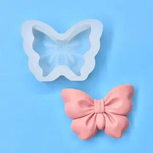 Vue détaillée du moule en silicone nœud papillon et produit fini en résine rose.