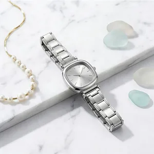 Primo piano di un orologio quadrato minimalista in acciaio inossidabile argento su marmo