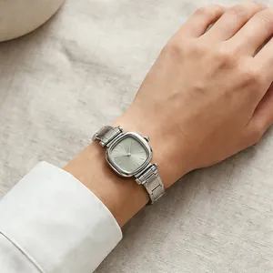 Primo piano di un orologio minimalista quadrato in acciaio inossidabile al polso