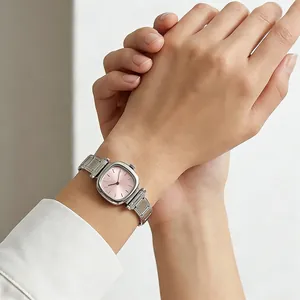 Primo piano di un orologio quadrato in acciaio argentato con quadrante rosa al polso.