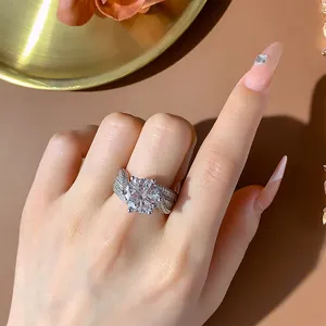 Close-up of a sparkling luxury 5-carat six-prong simulated diamond ring on a finger.