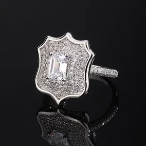 Macro view of a men's shield-shaped fashion ring with emerald-cut and pavé-set zircons