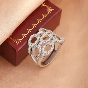 Detailed macro view of an intricate hollow-out silver ring pavé-set with sparkling stones