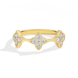 Detail view of an elegant gold ring with four-leaf clover cubic zirconia clusters.