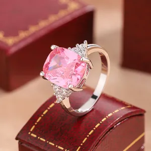 Macro view of a silver engagement ring with a cushion-cut pink cubic zirconia