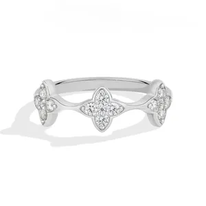 Close-up detail of an elegant silver ring featuring three diamond-pavé flower motifs