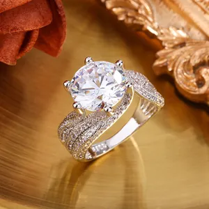 Detailed close-up of a luxurious 5-carat six-prong crown style ring with a paved band.