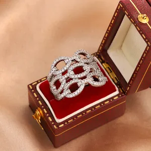Detail view of a silver-toned hollow-out crystal ring inside a vintage red jewelry box.