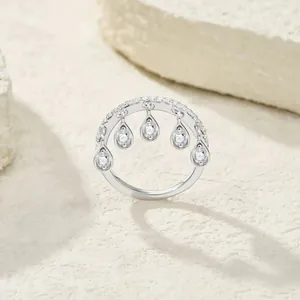 Close-up of elegant silver ring featuring five dangling teardrop cubic zirconia charms