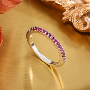 Macro detail of silver band ring featuring a row of vibrant magenta gemstones
