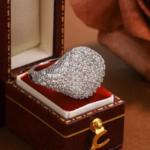 Close-up detail of a luxury full-pave signet ring showcased in a vintage red jewelry box