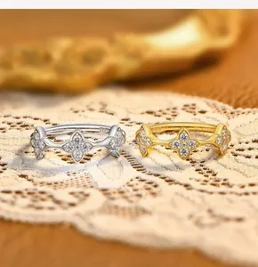 Exquisite macro detail of silver and gold clover rings with stone inlay on lace