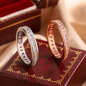 Macro view of silver and rose gold eternity rings with square-cut cubic zirconia.