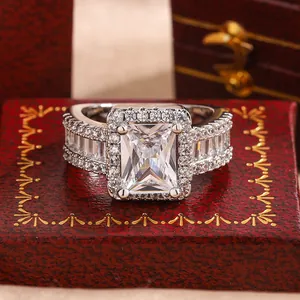 Detailed close-up of a silver-toned zircon engagement ring on a red box