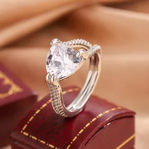 Detaillierte Nahaufnahme eines eleganten herzförmigen Rings mit Pavé-Besatz auf Rot