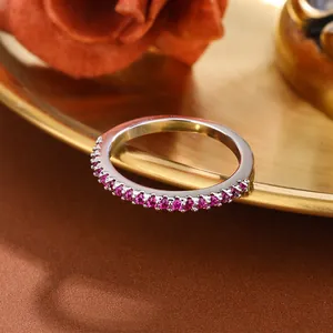 Macro detail of silver half-eternity ring with purple and red synthetic gemstones