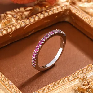 Macro detail of a silver half-eternity ring with sparkling pink gemstones for women.