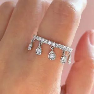 Close-up macro detail of an elegant silver ring with five sparkling teardrop dangles