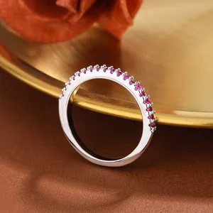 Exquisite close-up of a silver half eternity ring with set red and purple gemstones