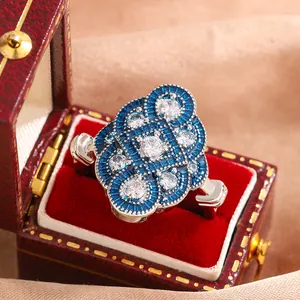 Detailed macro view of a vintage silver ring with blue enamel and white crystals.