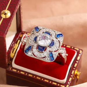 Close-up of vintage silver ring with blue and white zirconia in a red velvet gift box.