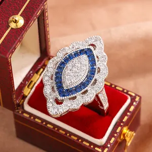 Détail macro d'une bague de fiançailles luxueuse en saphir bleu et topaze blanche
