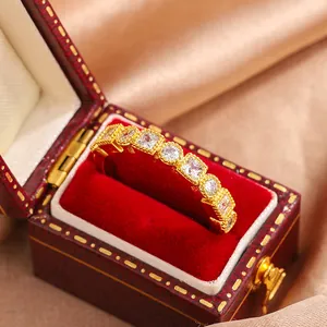 Detailed view of gold-plated lace ring with sparkling white stones in a vintage jewelry box