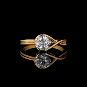 Elegant gold-plated ring with round moissanite in teardrop bezel and twisted band design