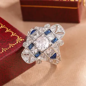 Vista dettagliata di un anello decorato color argento con pietra centrale e accenti blu