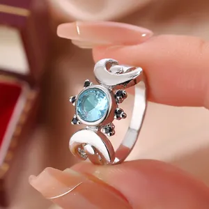Close-up detail shot of a silver celestial moon ring with a sparkling round blue zircon stone