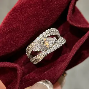 Macro detail of a marquise-cut zircon ring with micro-pave setting on red velvet