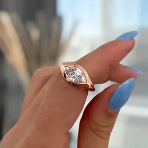 Close-up of a marquise-cut diamond engagement ring in 18k gold finish on a finger