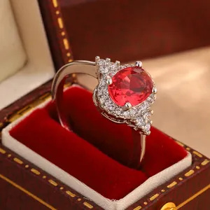Elegant oval faux ruby ring with a sparkling crystal halo shown in a jewelry box